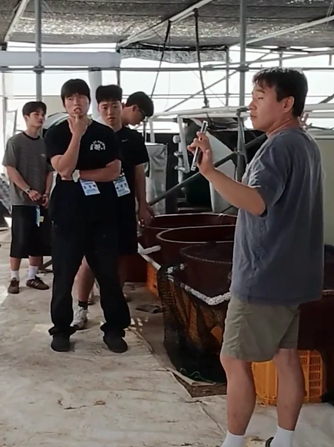 하우스 안에서 학생들에게 수경재배 시설을 설명하는 모습