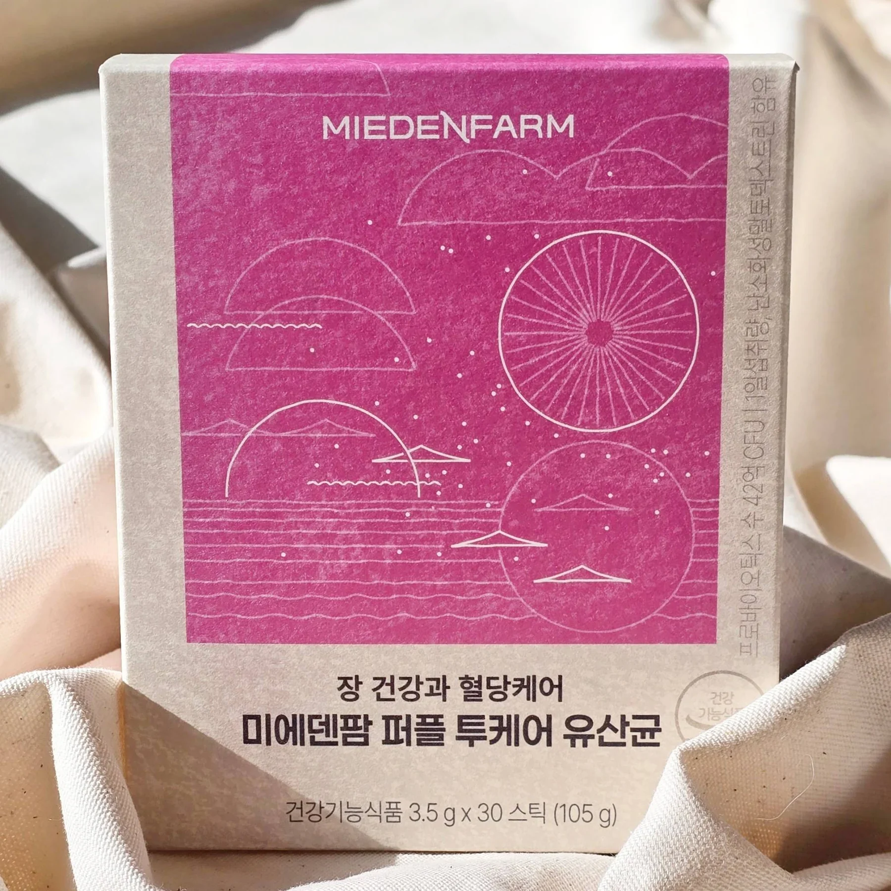 천 위의 퍼플 투케어 유산균 상자(미에덴팜 직접 촬영)